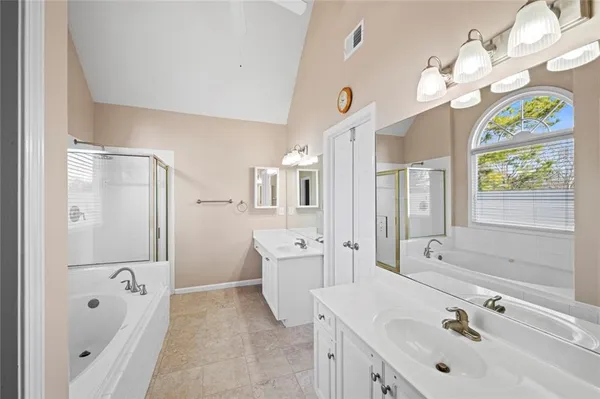a spacious bathroom with a tub sink and mirror