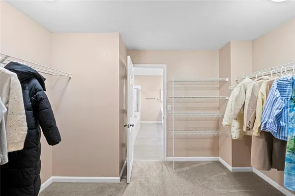 a view of walk in closet with clothes and shoes