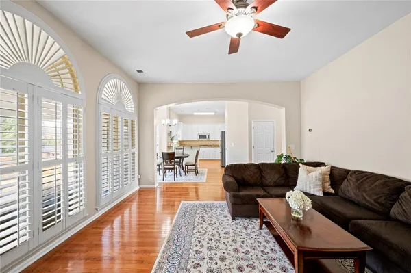 a living room with furniture and a large window with wooden floor