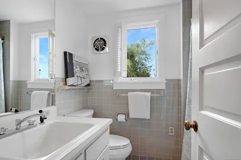 a bathroom with a sink a toilet and a mirror