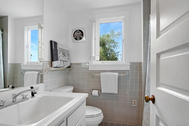 a bathroom with a sink a toilet and a mirror