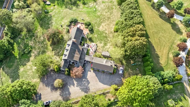 an aerial view of residential house with outdoor space and trees all around