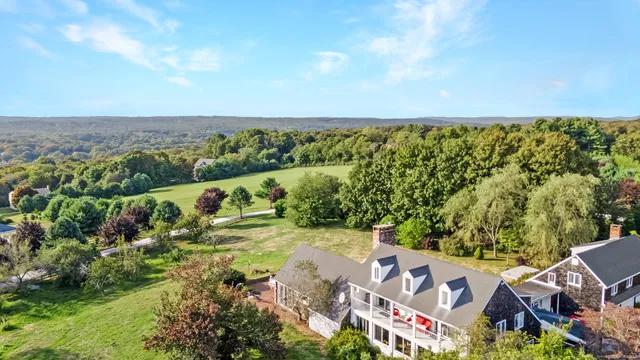 an aerial view of residential houses with outdoor space and trees