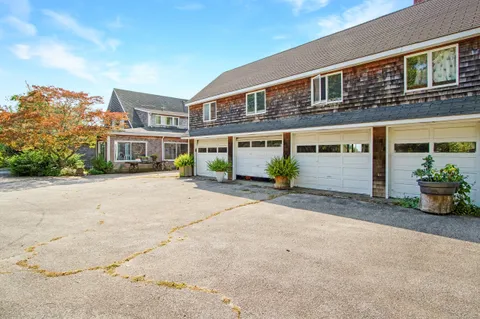 a front view of a building with street and trees
