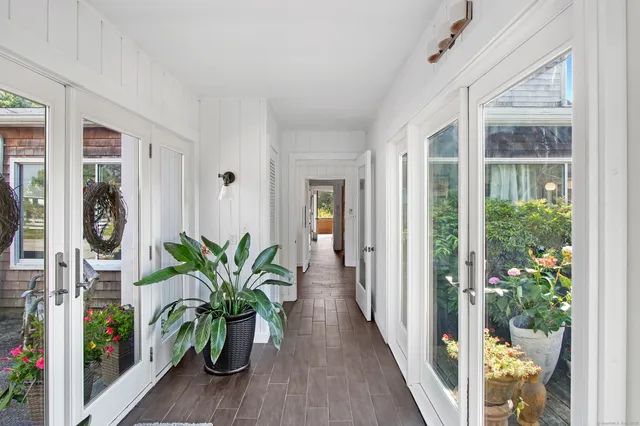 a view of a hallway with wooden floor and table and potted plant