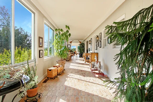 a view of a porch with chairs and potted plants