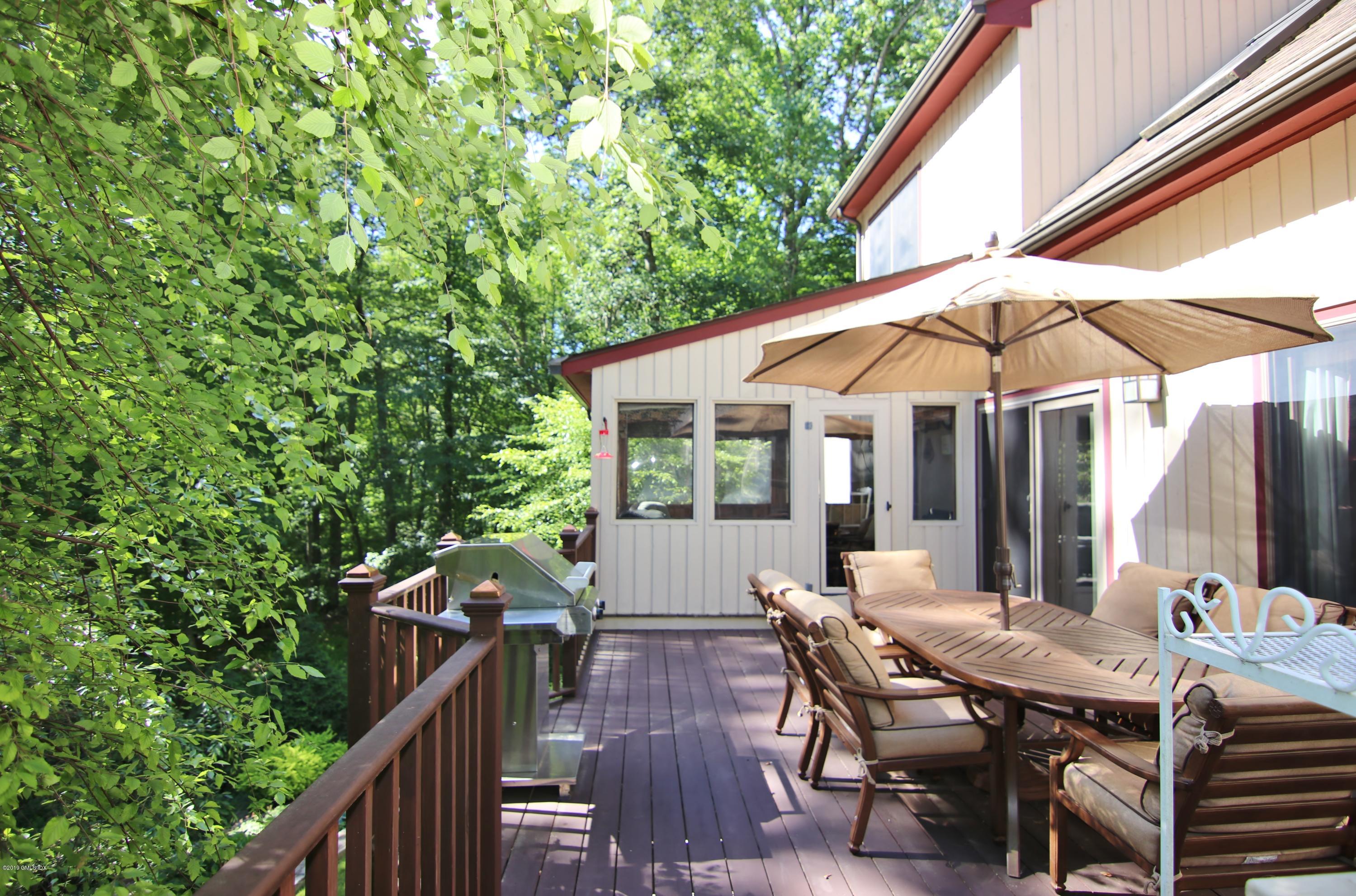 737 Rock Rimmon Road Stamford, CT 06903 - Photo 35 of 38 a view of a patio with a table and chairs under an umbrella
