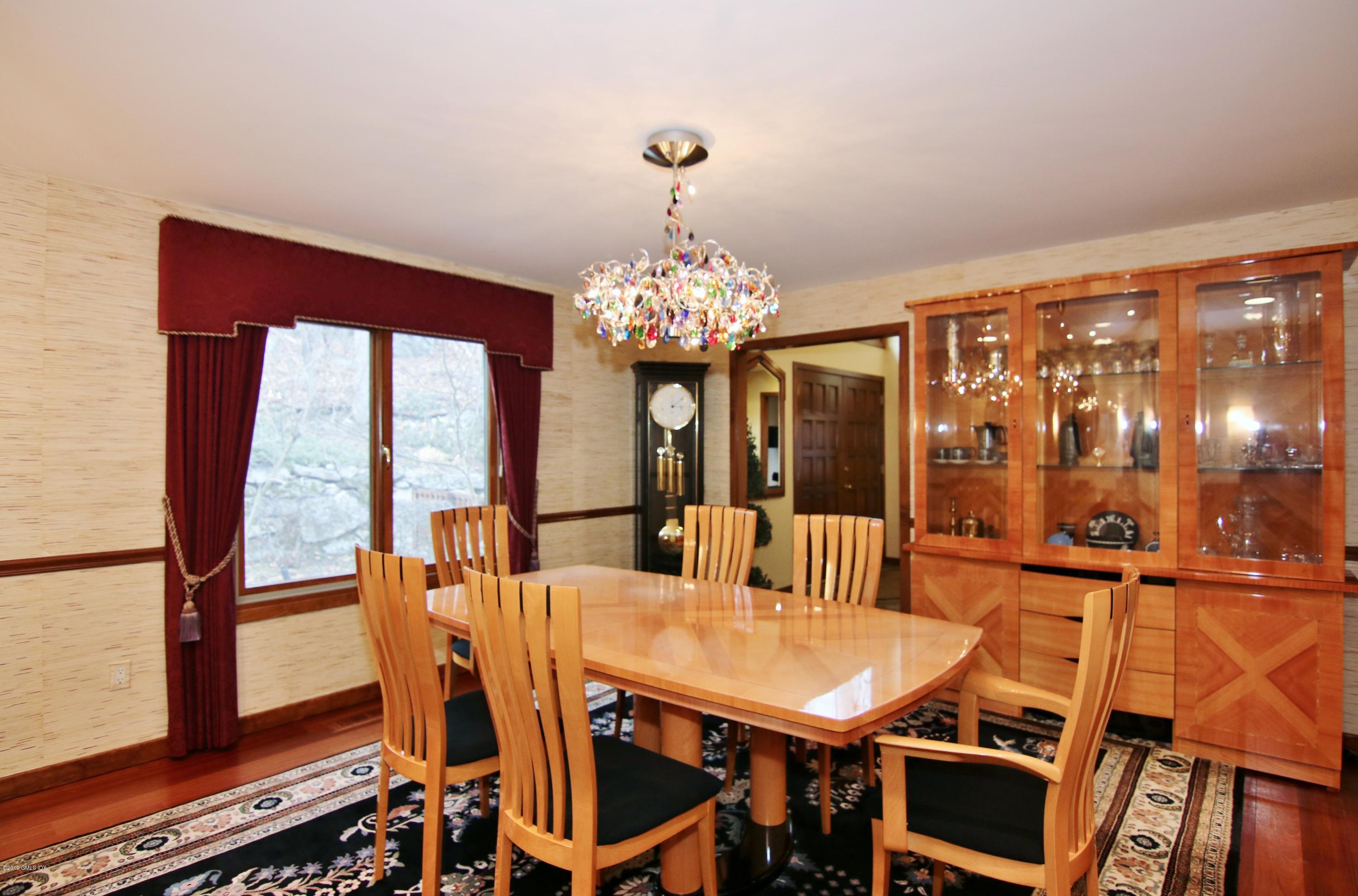 737 Rock Rimmon Road Stamford, CT 06903 - Photo 9 of 38 a view of a dining room with furniture a chandelier and wooden floor