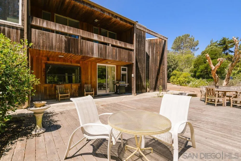 4954 Sun Valley Road Del Mar, CA 92014 - Photo 13 of 32 a view of a patio with table and chairs with wooden floor and fence
