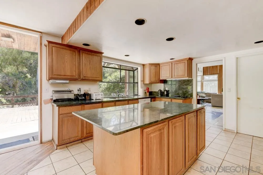 4954 Sun Valley Road Del Mar, CA 92014 - Photo 9 of 32 a kitchen with stainless steel appliances granite countertop a sink stove and refrigerator