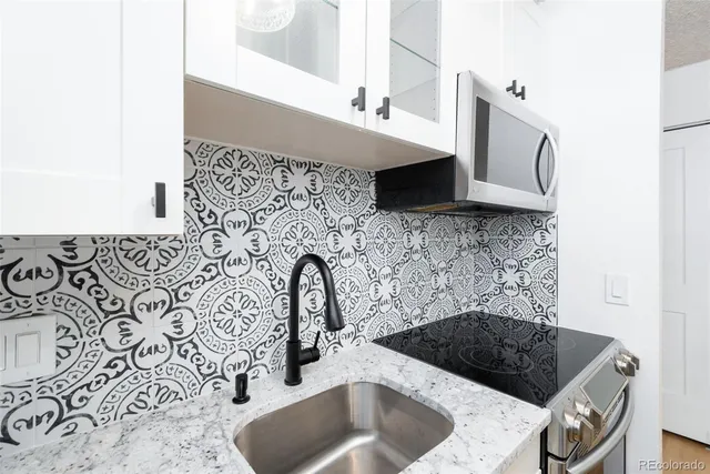 a kitchen with a sink and a stove top oven