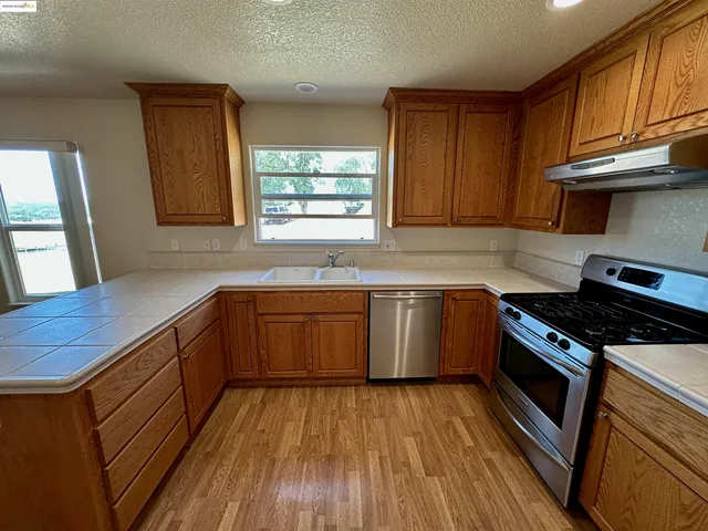 a kitchen with granite countertop wooden floors and stainless steel appliances