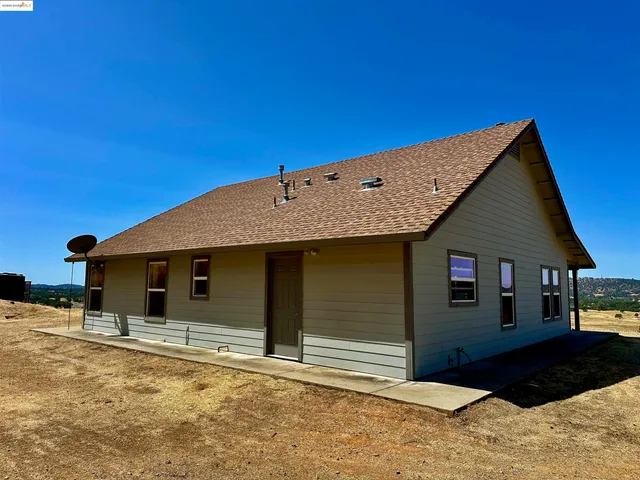 a view of a house with wooden deck and a basket ball court