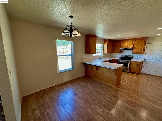 a view of kitchen with sink refrigerator and window