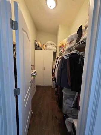 a view of walk in closet with clothes and shoes