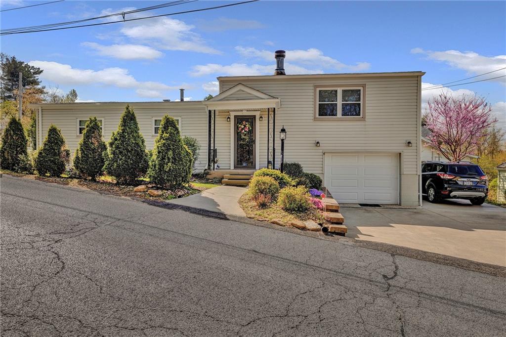 754 Wolf Avenue Rochester, PA 15074 - Photo 1 of 25 a front view of a house with a garden and mountain view