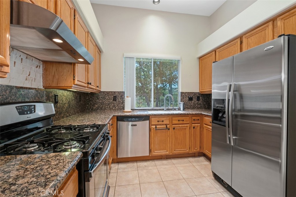 35 Vía Encanto Rancho Santa Margarita, CA 92688 - Photo 11 of 40 a kitchen with stainless steel appliances granite countertop a stove a sink and a refrigerator