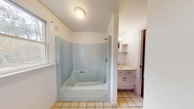 a bathroom with a granite countertop sink a toilet and shower