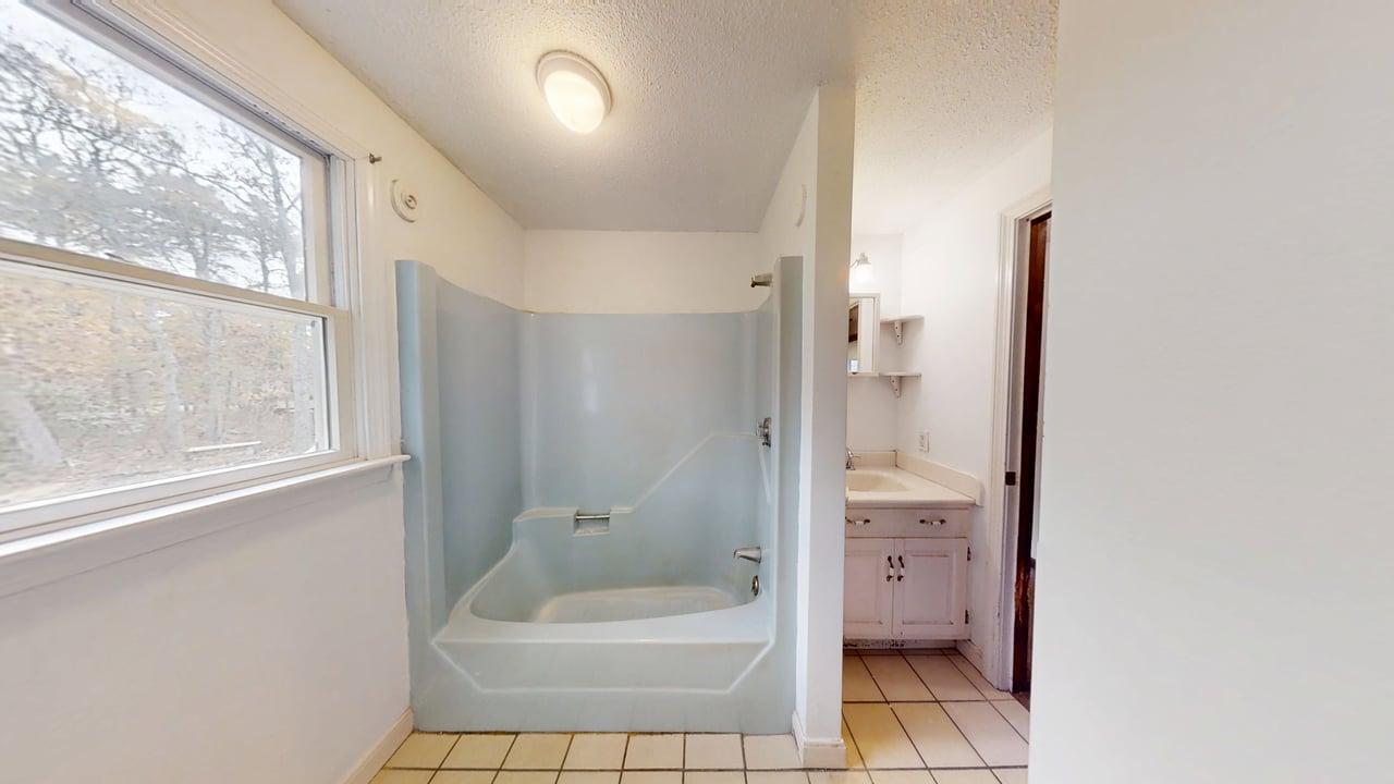 765 Millstone Road Brewster, MA 02631 - Photo 13 of 16 a bathroom with a granite countertop sink a toilet and shower