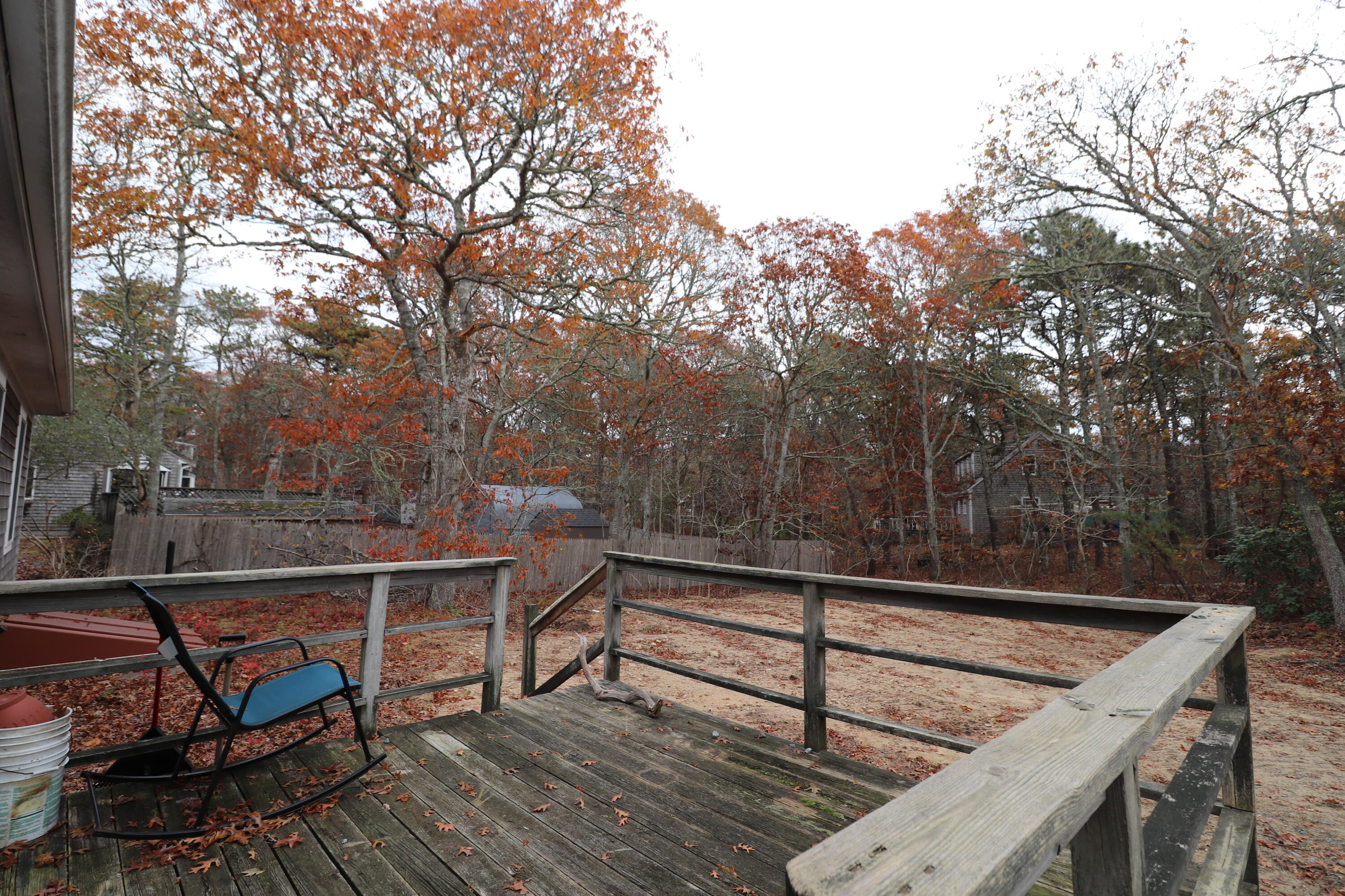 765 Millstone Road Brewster, MA 02631 - Photo 16 of 16 a view of a roof deck with wooden fence and trees
