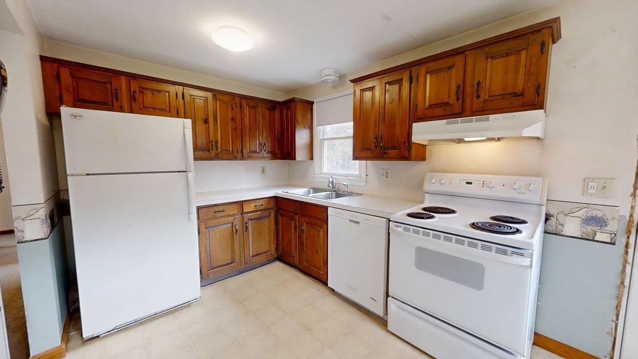 765 Millstone Road Brewster, MA 02631 - Photo 2 of 16 a kitchen with a refrigerator sink stove and cabinets