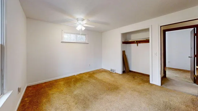 an empty room with windows and closet