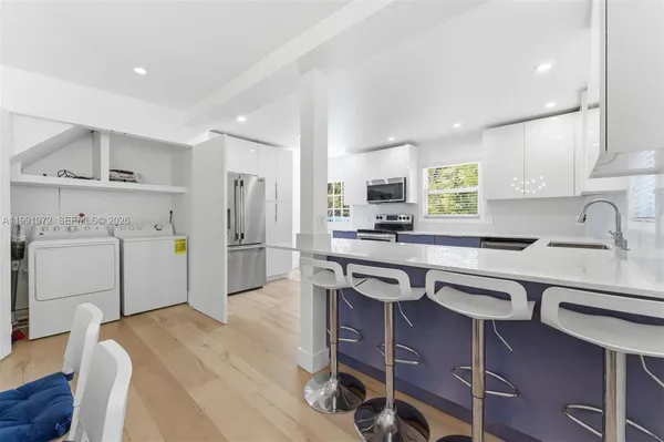 a kitchen that has a sink a stove a refrigerator cabinets and wooden floor