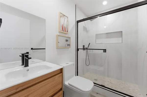 a bathroom with a granite countertop sink toilet and shower