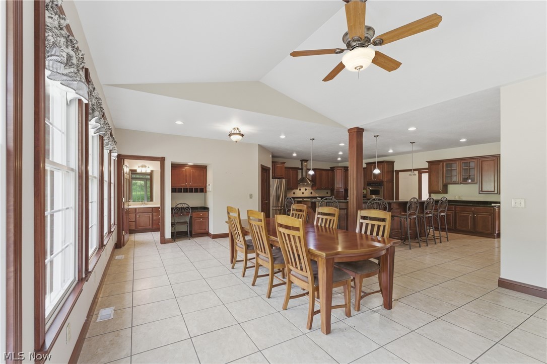 2184 Brenner Road Northeast Carrollton, OH 44615 - Photo 11 of 50 Spacious room featuring tile flooring, a vaulted ceiling with a fan, and a wall of windows