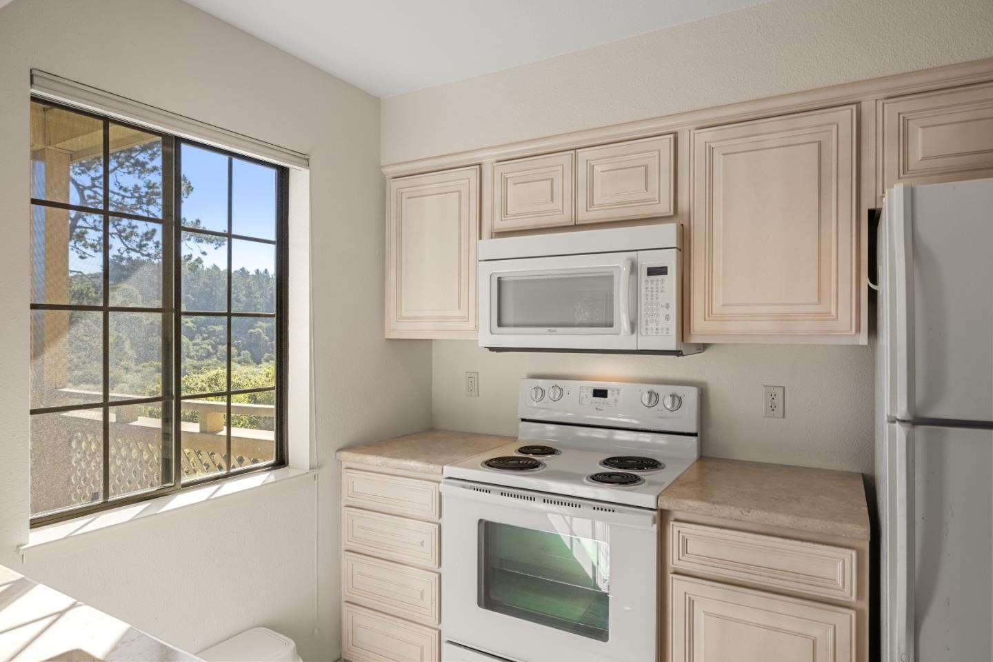 121 Quail Run Court Del Rey Oaks, CA 93940 - Photo 12 of 33 a kitchen with white cabinets and black appliances