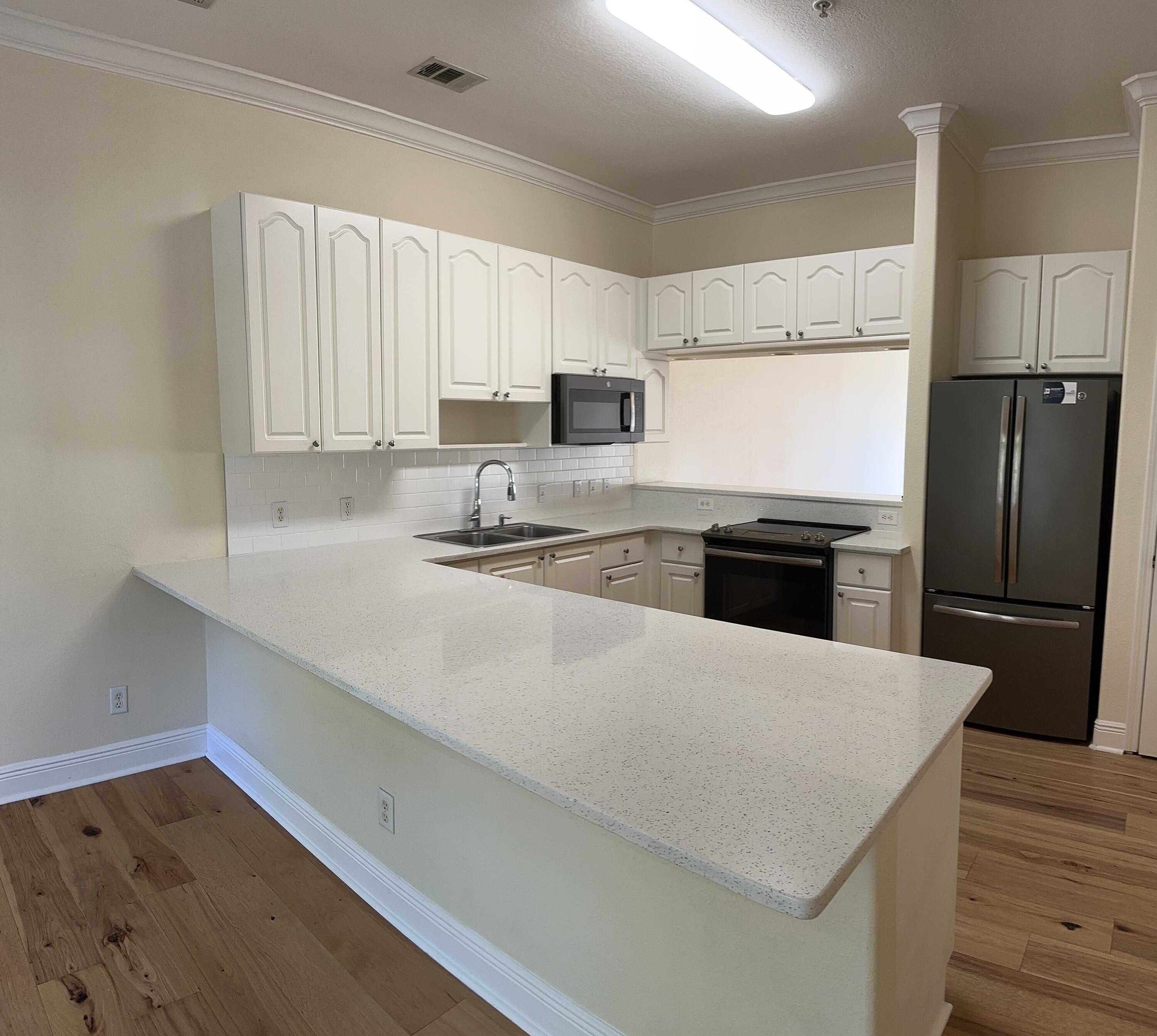 56 Spires Lane, Unit E16 Santa Rosa Beach, FL 32459 - Photo 11 of 17 a kitchen with refrigerator cabinets and wooden floor