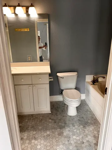 a bathroom with a toilet a sink and mirror