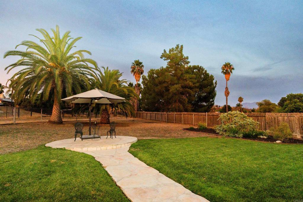 16327 Scarbery Road Ramona, CA 92065 - Photo 5 of 40 a garden with a bench and trees in the background