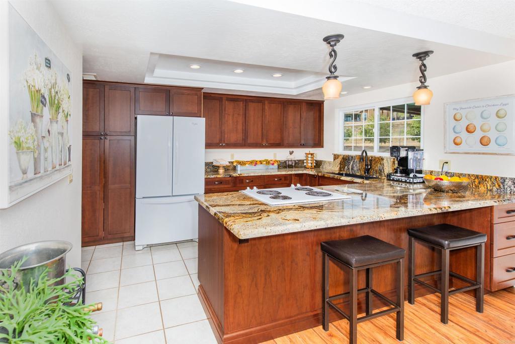 16327 Scarbery Road Ramona, CA 92065 - Photo 10 of 40 a kitchen with stainless steel appliances granite countertop a sink counter space and a refrigerator