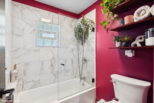 a white toilet sitting next to a bath tub and shower