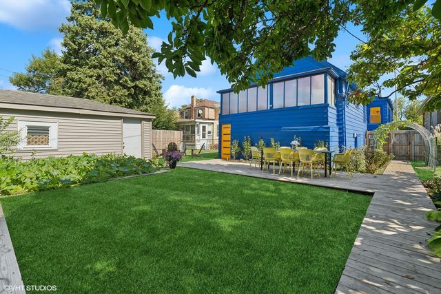 a view of a house with backyard and a tree