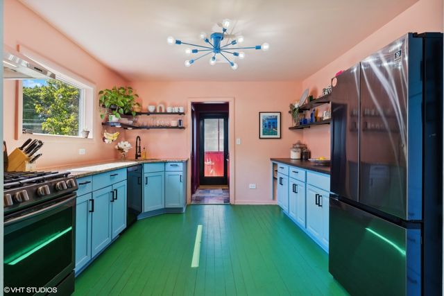 a kitchen with cabinets a island and stainless steel appliances