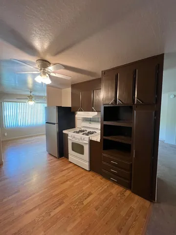 a kitchen with granite countertop a refrigerator and a stove top oven