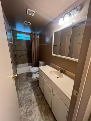 a bathroom with a sink a toilet a mirror and shower