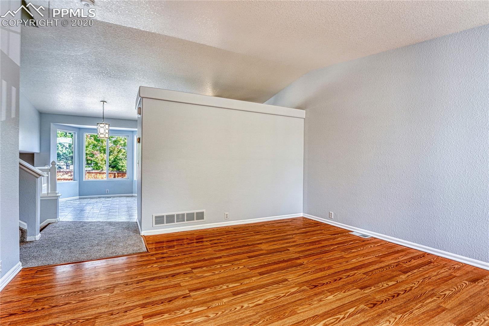 6554 Hannah Rose Road Colorado Springs, CO 80923 - Photo 6 of 29 Note the vaulted ceiling, new carpet and updated light fixture.