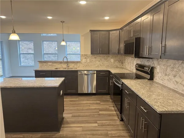 a kitchen with granite countertop a stove a sink and a window