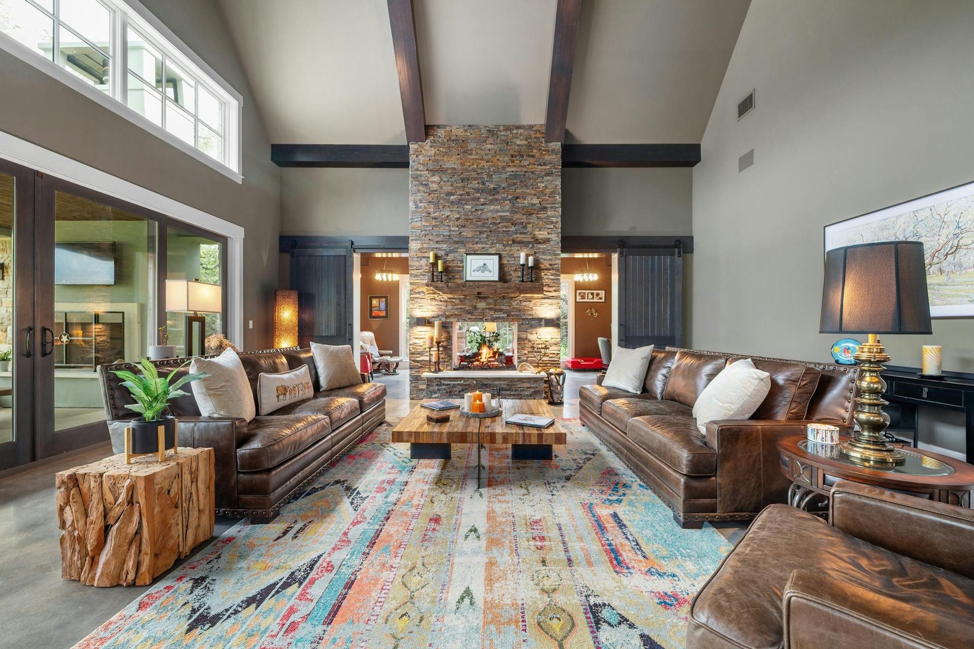 1330 Ranchers Club Lane Driftwood, TX 78619 - Photo 6 of 40 Living area with vaulted ceiling, a stone fireplace, french doors, and finished concrete floors
