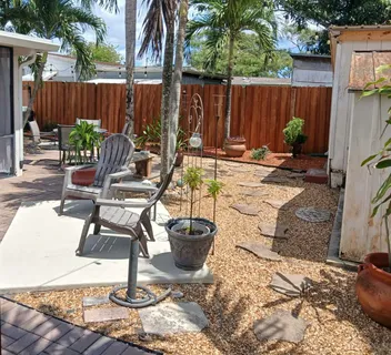 a view of a backyard with chairs and a fire pit