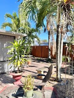 a view of a backyard with chairs potted plants