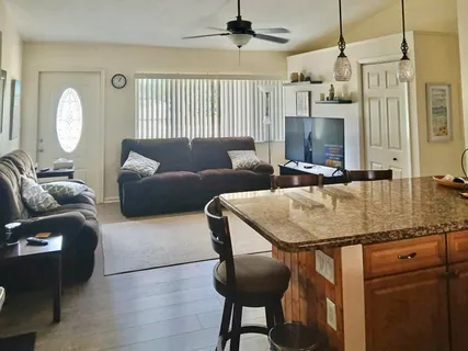 a living room with furniture a flat screen tv and a window