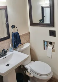a bathroom with a toilet sink and mirror