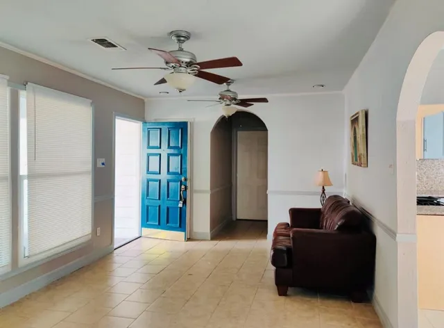a living room with furniture and a ceiling fan