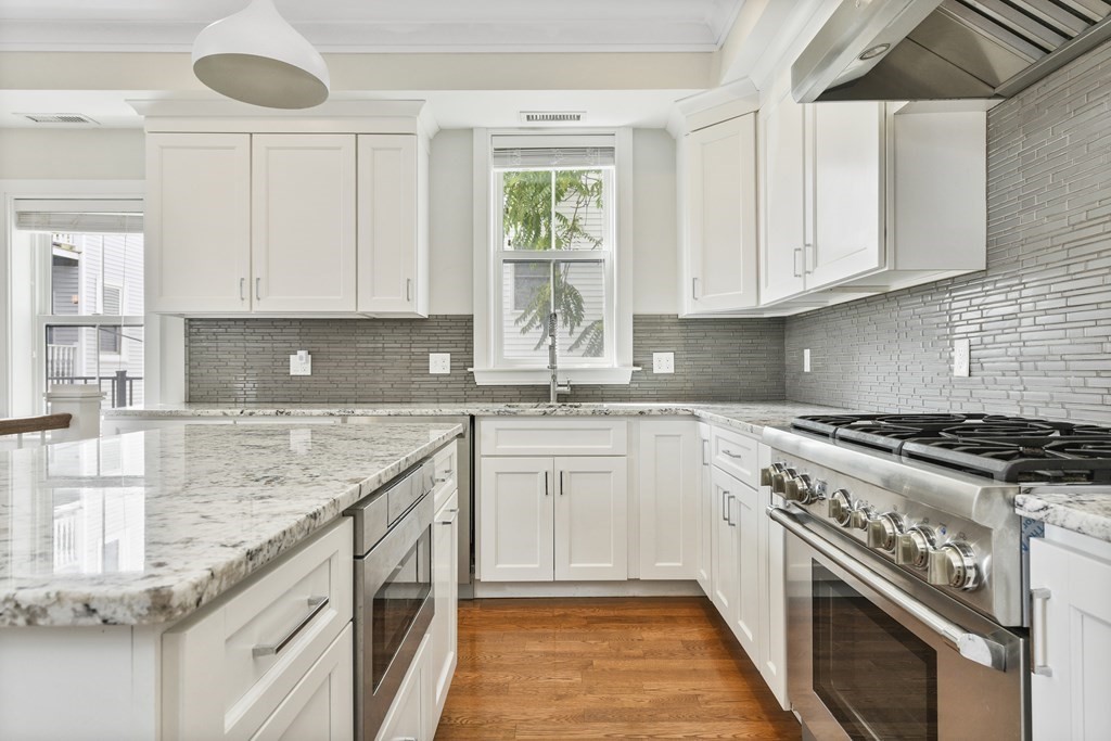 a kitchen with granite countertop a sink stainless steel appliances and cabinets