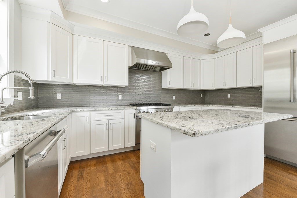 1514 R Columbia Road, Unit 2 Boston, MA 02127 - Photo 3 of 28 a kitchen with stainless steel appliances granite countertop a sink stove and white cabinets