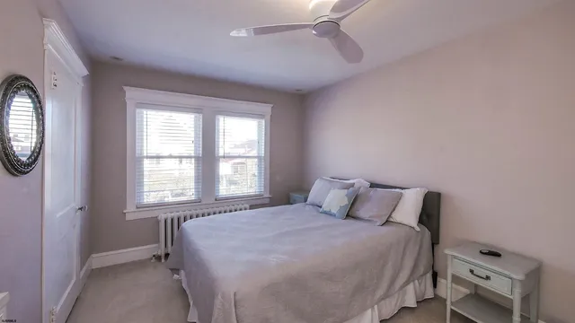 a bedroom with a bed a mirror and a window